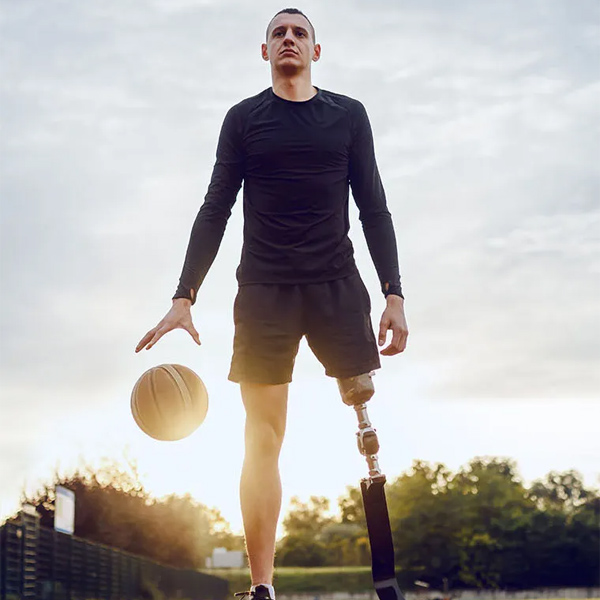 man with a prosthetic leg dribbling a basketball