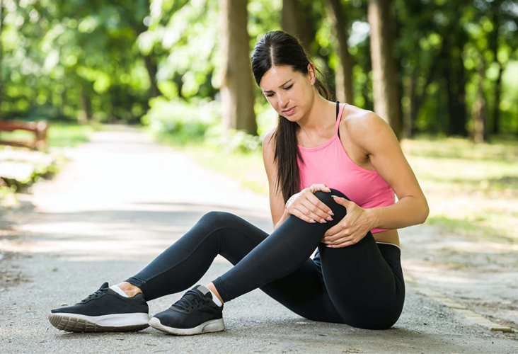 woman grabbing knee in pain