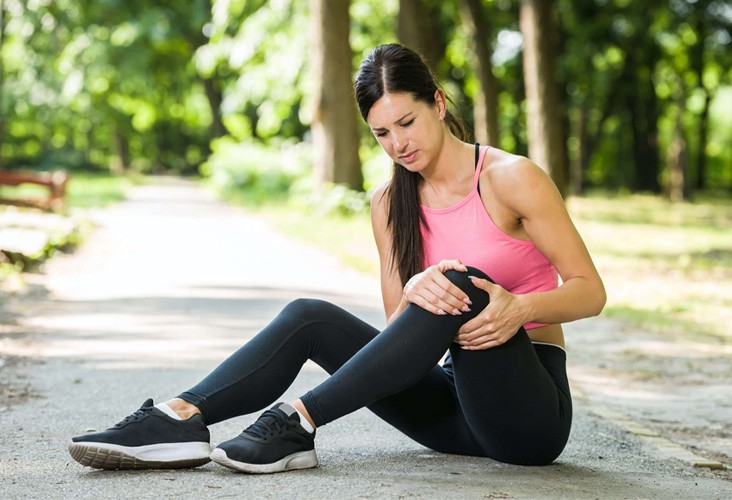 A Woman Grabbing Her Knee in Pain During Exercise in New York & New Jersey
