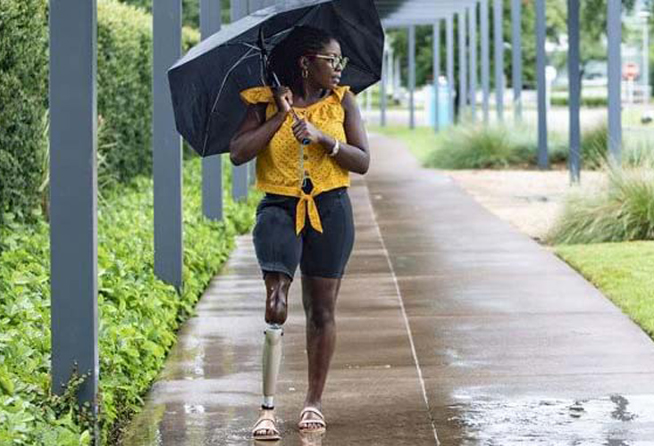 woman walking through the rain with her prosthetic