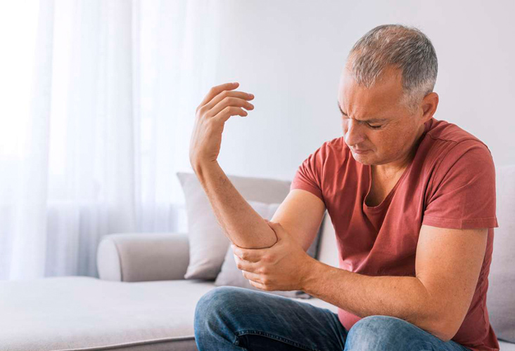 Man clutching elbow in pain