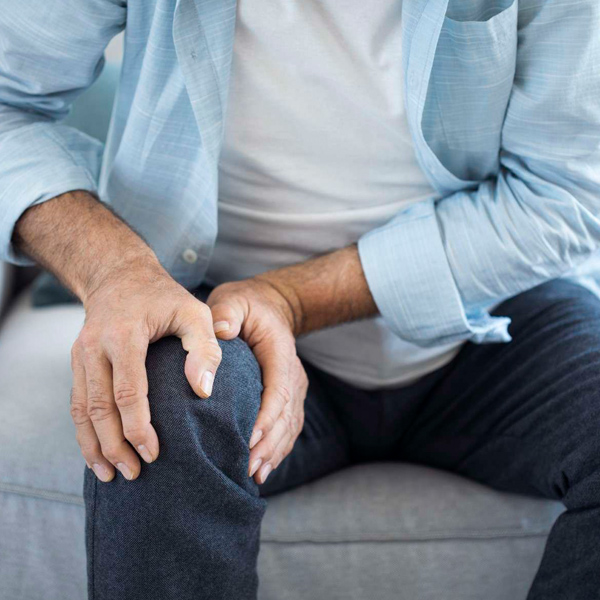 man grabbing his knee in pain